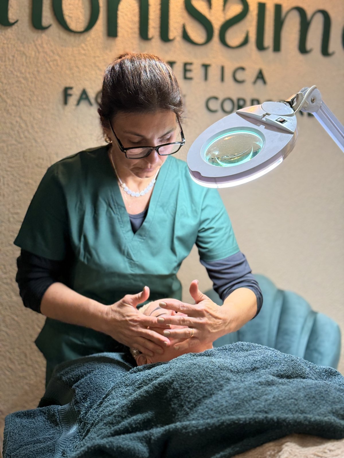 Silvana haciendo un tratamiento facial en Monissima, con el logo del centro en la pared