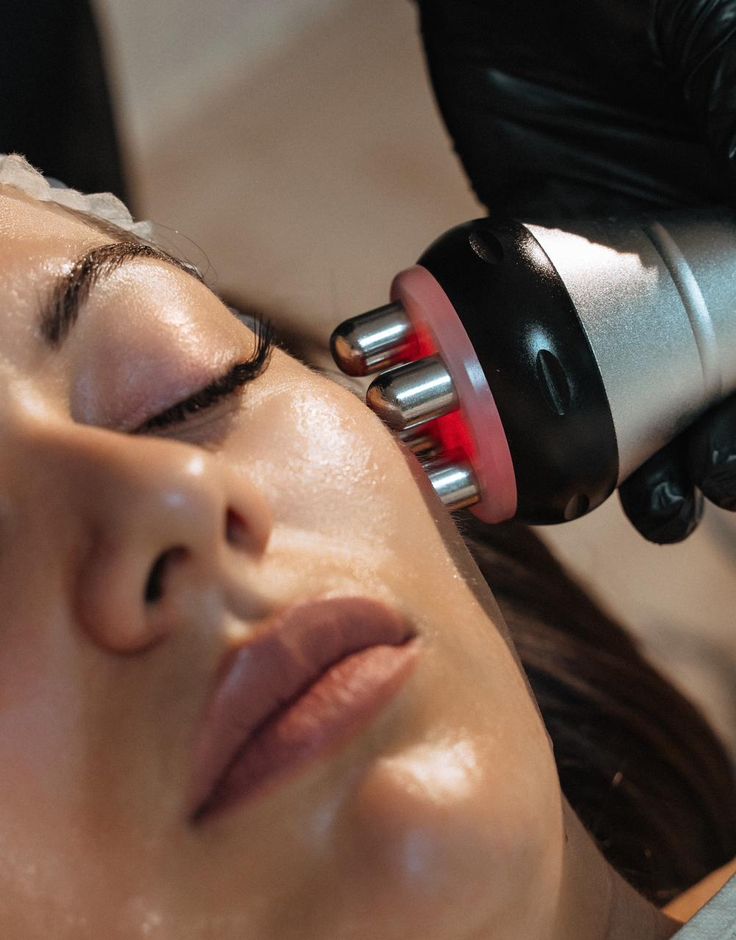 Mujer con los ojos cerrados durante un tratamiento facial con aparatología